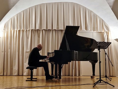 Jürgen Kruse spielt konzentriert am Flügel im Konzertsaal der BFS Musik.