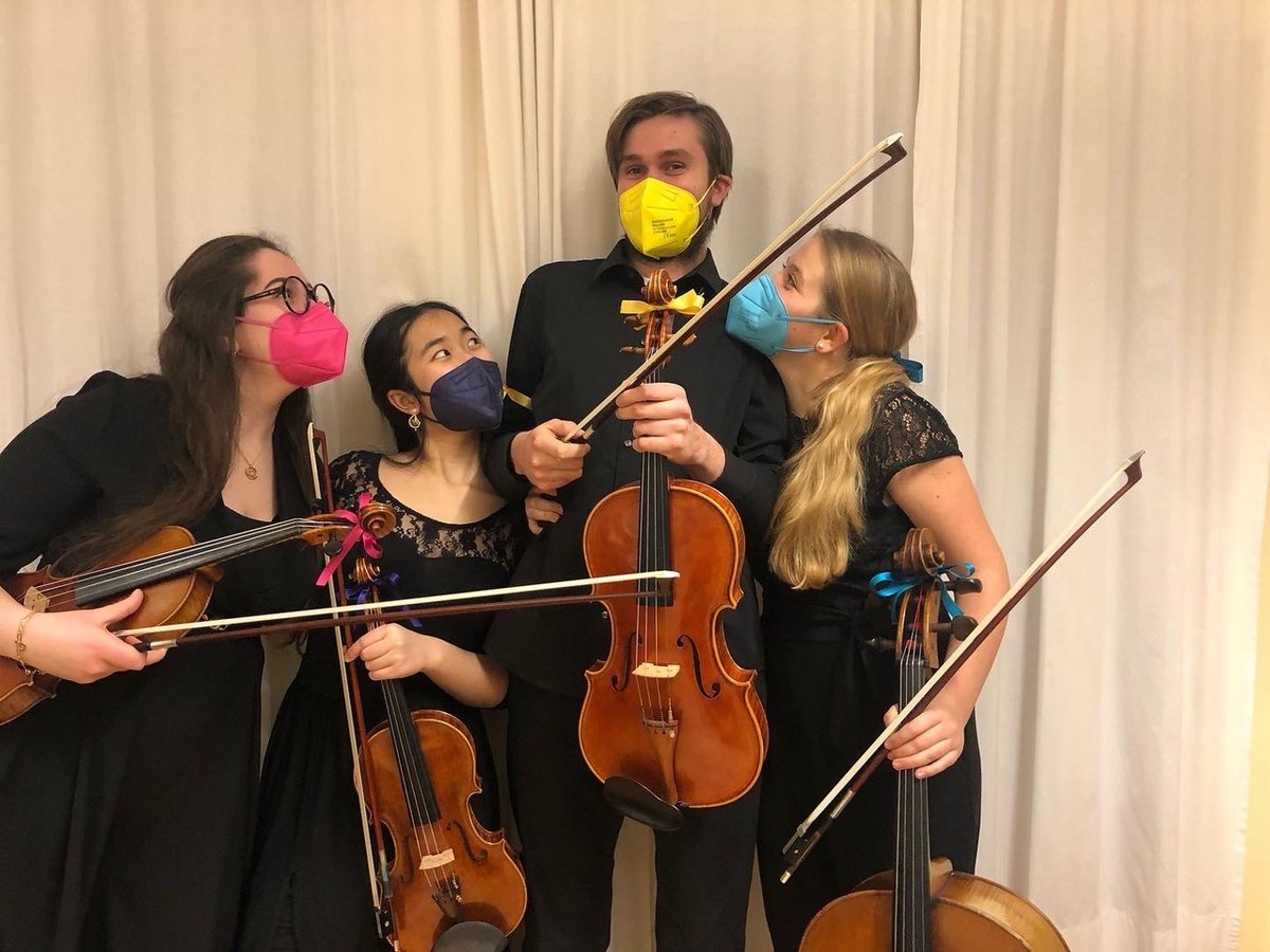 Gruppenfoto: Vier Musiker*innen eines Streichquartetts stehen beieinander. Sie tragen bunte FFP2-Masken.