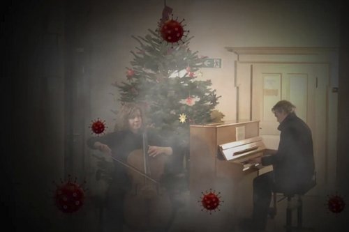 2 Kollegen musizieren unter dem Weihnachtsbaum