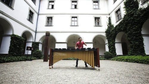 Im Innenhof der BFS Musik steht ein Schüler und spielt auf seinem Marimbaphon
