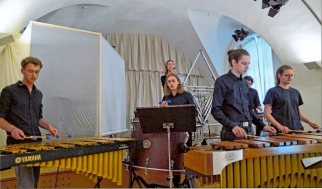 Shadow Drums Auf der Bühne stehen sechs Musikerinnen und Musiker und musizieren gemeinsam auf Percussioninstrumenten.